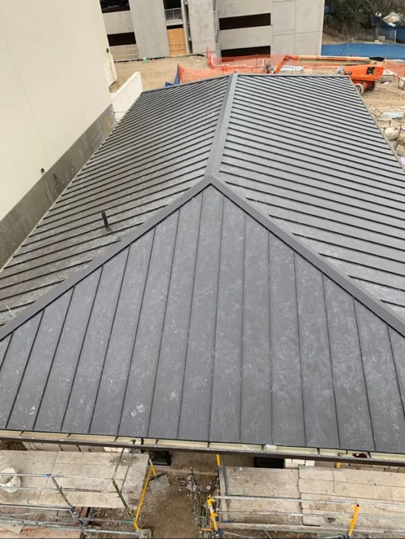 Commercial metal roof construction with crane equipment in Tehaleh